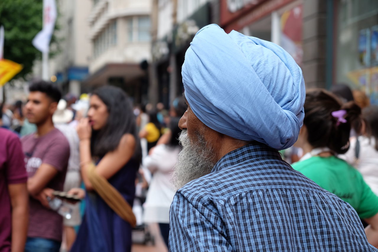 REAR VIEW OF PEOPLE WALKING ON STREET