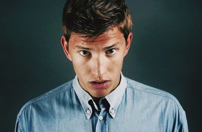 Portrait of young man against gray background