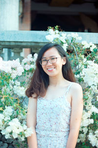 Portrait of smiling woman standing against plants