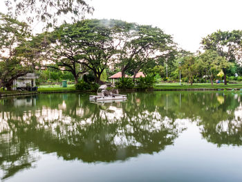 Scenic view of lake by trees against sky