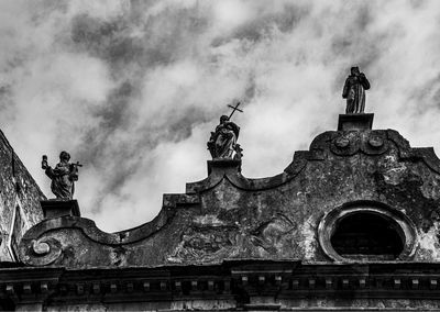 Stone religious statues on the roof of an ancient church in vittorio veneto, treviso, italy