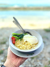 Close-up of hand holding soup in bowl