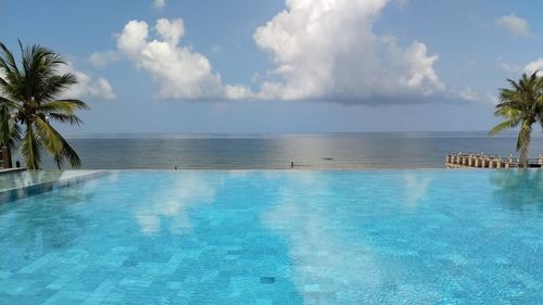 View of swimming pool by sea against sky