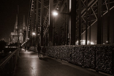 Empty road along illuminated street lights at night