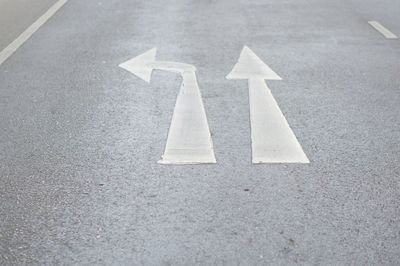 High angle view of arrow symbols on road in city