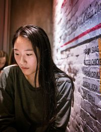 Thoughtful woman looking away down while sitting in cafe