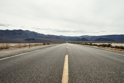 Road by landscape against sky