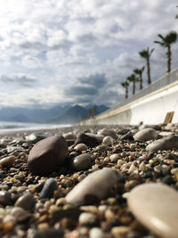 Surface level of stones on beach against sky