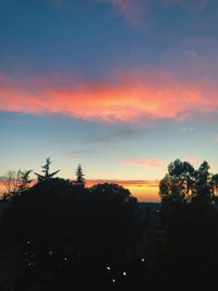 Silhouette trees against orange sky