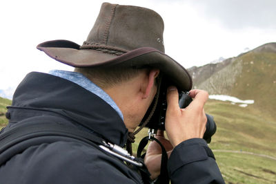 Side view of male hiker photographing mountains