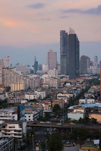 Modern buildings in city against sky during sunset