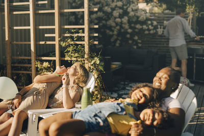 Mothers spending leisure time with daughters at back yard during party