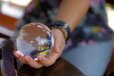 Midsection of woman holding crystal ball