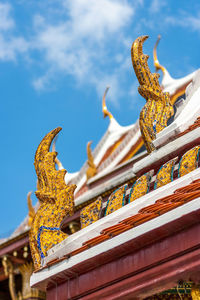 Low angle view of statues on building against sky