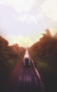 Railroad tracks amidst trees and buildings against sky