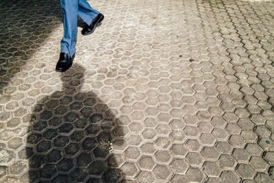 Low section of man standing on road