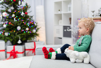 Portrait of boy playing with christmas tree at home