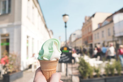 Midsection of woman holding ice cream in city