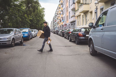 Delivery man with package walking on street in city