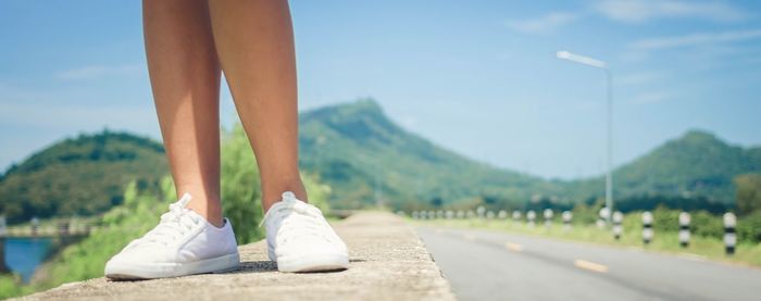 Low section of woman walking on road