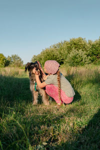 Little girl hugging playing with dog walking spending time together. child with pet in summer meadow