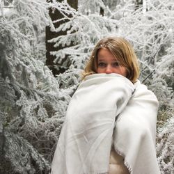 Portrait of young woman wrapped in snow