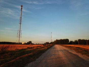 Road amidst field against sky