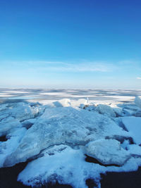 Scenic view of frozen sea against blue sky