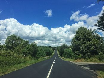 Road amidst trees against sky