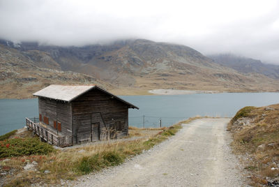 Built structure by lake against sky