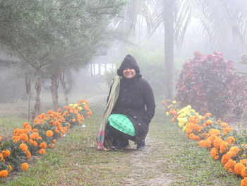 Portrait of young woman standing in park during winter