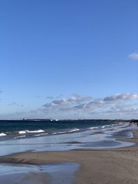 Scenic view of beach against blue sky