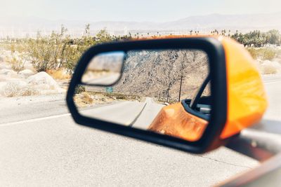Road reflecting on side-view mirror of car