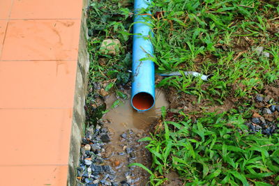 High angle view of pipe on field against wall