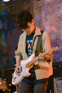 Full length of a young man playing guitar