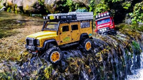 Yellow car on rock by road