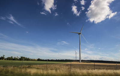 Windmill on field against sky