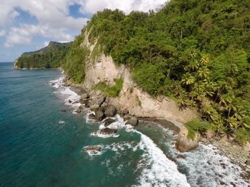 Scenic view of sea by cliff against sky