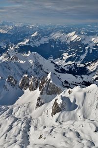 Aerial view of snow covered mountains against sky