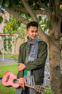 Young man standing on tree trunk