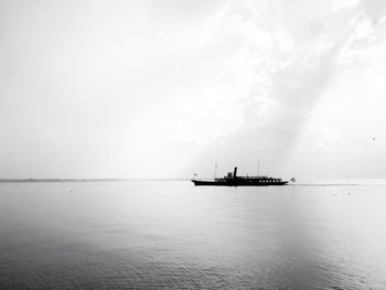 Silhouette ship sailing on sea against sky