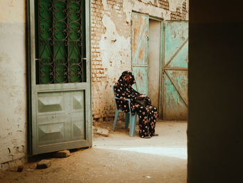 Rear view of woman standing by window