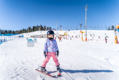 Full length portrait of boy on snow covered landscape