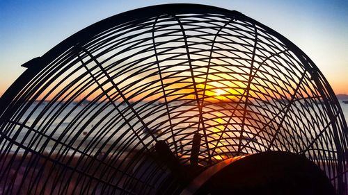 Silhouette electric fan against sky during sunset