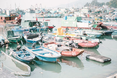 Boats moored at harbor against sky