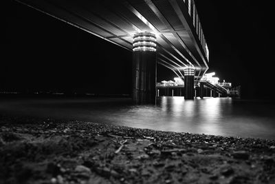 Bridge over illuminated city against sky at night