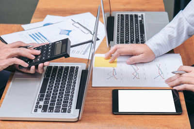 Cropped image of colleagues working at desk in office