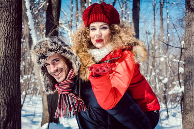 Portrait of smiling couple against trees