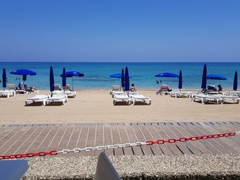 Scenic view of beach against clear blue sky