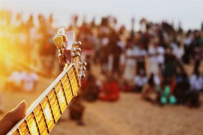 Hand playing guitar at beach